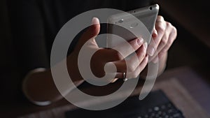 Hands of a young woman surfing internet on smartphone in cafe