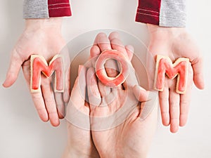 Hands of a younger daughter and her mother`s