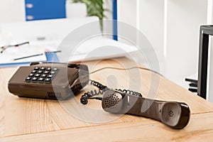 handset of black stationary telephone on table