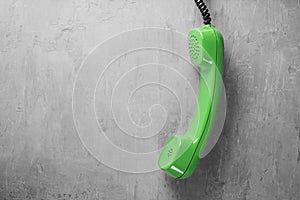 Handset from landline phone on a background wall