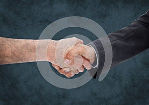 Handshake against dark blue grunge background