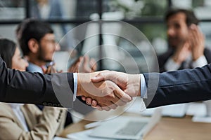 Handshake in agreement against young business people in board room meeting