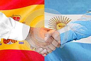 Handshake on Argentina and Spain flag background