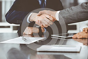 Handshake as successful negotiation ending, close-up. Unknown business people shaking hands after contract signing in