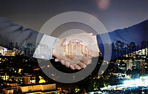 Handshake of business partners on city background - Double exposure photo