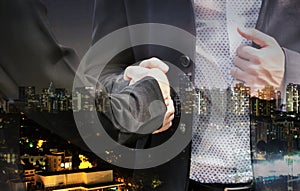 Handshake of business partners on city background - Double exposure photo
