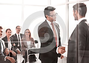 Handshake business partners at the meeting in the conference room