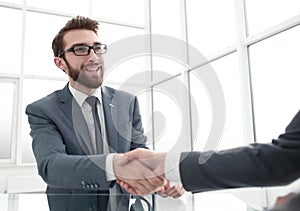Handshake business partners over the table in the office