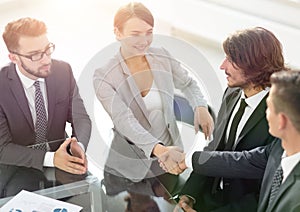 Handshake business partners for their Desk