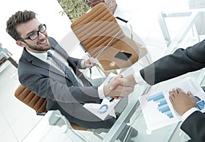 Handshake business partners at your Desk