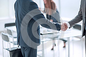 Handshake of business people in the background of the office