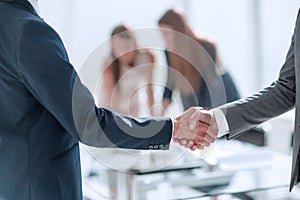 Handshake of business people in the background of the office