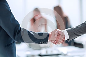 Handshake of business people in the background of the office