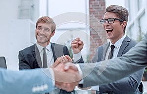 Handshake of business people on a blurred office background.