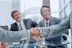 Handshake of business people on a blurred office background.