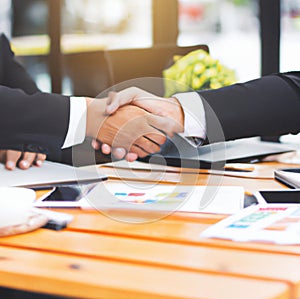 Handshake and business people concept. Two men shaking hands, blurred office background.