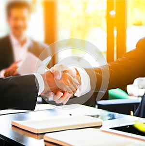 Handshake and business people concept. Two men shaking hands blurred office background.