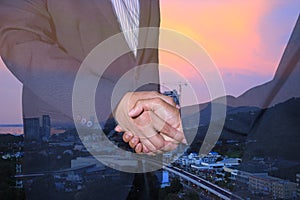 Handshake and business people concepts. Two men shaking hands on city background.