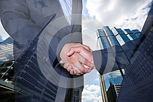 Handshake and business people concepts. Two men shaking hands on cityscape background.