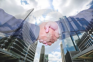 handshake and business people concepts. Two men shaking hands isolated on cityscape background.