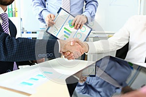 Handshake of business people at meeting and signing agreement