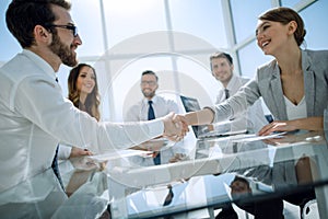 Handshake of a businessman and business woman over a Desk