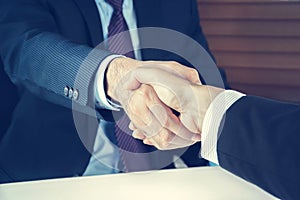 Handshake of businessmen in vintage tone