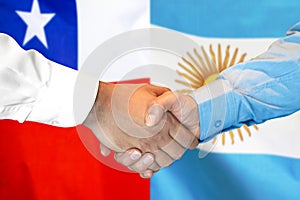 Handshake on Chile and Argentina flag background