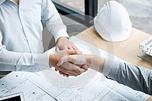 Handshake of collaboration, Construction engineering or architect discuss a blueprint and building model while checking