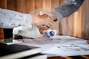 Handshake of collaboration, Construction engineering or architect discuss a blueprint and building model while checking