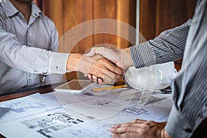 Handshake of collaboration, Construction engineering or architect discuss a blueprint and building model while checking