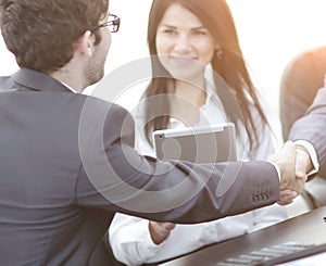 Handshake between colleagues in the workplace in the office