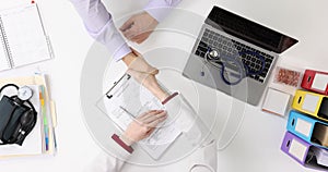 Handshake between doctor and patient in clinic, top view