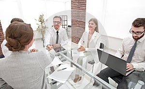 Handshake financial partners sitting at the office Desk