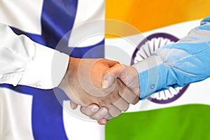 Handshake on Finland and India flag background