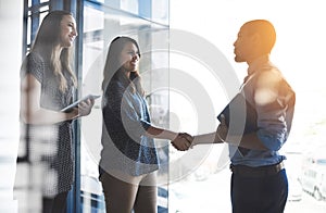 Handshake greeting between business women, entrepreneur and accountant banker with tablet and portfolio. Happy female