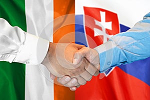 Podanie ruky na pozadí vlajky Írska a Slovenska. Koncepcia podpory