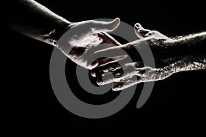 Handshake. Men holding hands isolated on black. Connection and human relations. Male hands rescue. Friendly handshake