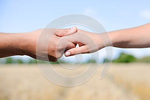 Handshake on outdoors blurred abstract nature background, image closeup