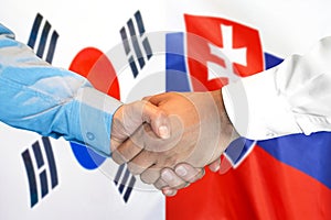 Podanie ruky na pozadí vlajky Južnej Kórey a Slovenska