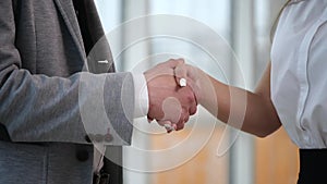 Handshake of two business people. Friendly partners are shaking hands. Blurred background. Close up. Slow motion. Slowmo