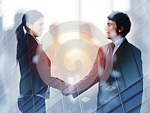 Handshake of two businessperson in office concept of partnership and teamwork.double exposure