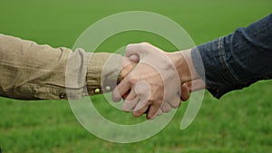 Handshake of two male hands in the field