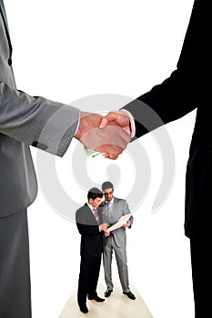 Handshake and two working businessmen