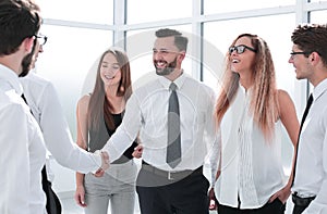 Handshake of young business partners in the office.
