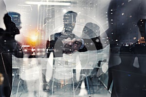 Handshaking business person in office. concept of teamwork and partnership. double exposure