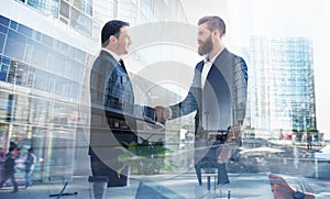 Handshaking business person in office. concept of teamwork and partnership. double exposure