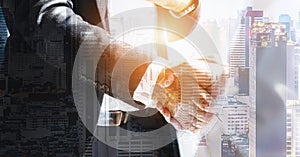 Handshaking of businessmen hands overlay with cityscape