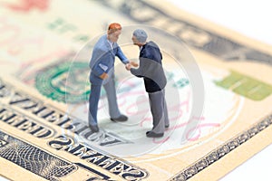 Handshaking businessmen on usa dollar banknote. Business company profitable deal.