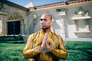 Handsom Indian Man Greeting Namaste in Gold Kurta at the Temple